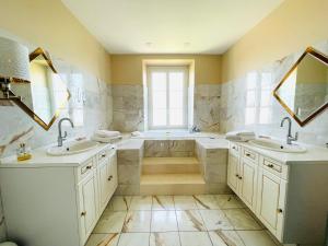 ein großes Badezimmer mit zwei Waschbecken und einer Badewanne in der Unterkunft La Villa Champagne Ployez-Jacquemart in Ludes