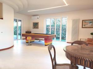un soggiorno con tavolo da ping pong e sedie. di Rho Mind Villa a Rho
