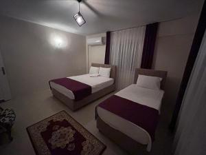 una camera d'albergo con due letti e una finestra di The Titanic hause otel a Pamukkale