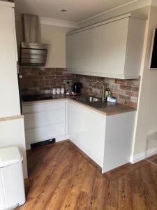 une cuisine avec des armoires blanches et un évier dans l'établissement Prancing Horse Cottage, à Sabden 10 autres photos