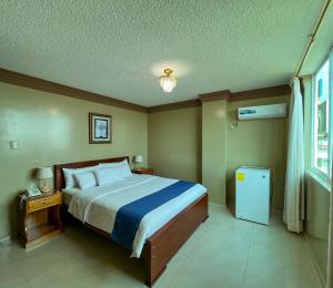 a bedroom with a large bed and a window at Apart Hotel Hamilton in Manta