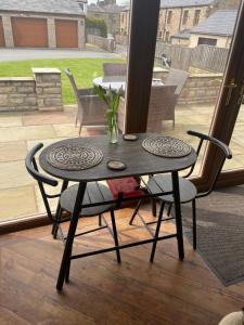 mesa con 2 sillas y mesa con patio en Prancing Horse Cottage en Sabden