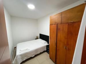 1 dormitorio pequeño con 1 cama y armario de madera en Hermoso y acogedor apartamento, en Cali