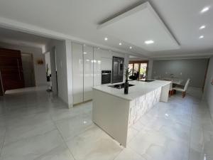 a large kitchen with a white island in a room at Casa Malta - St Sul in Goiânia