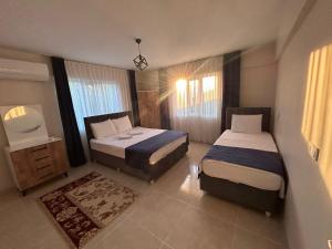 een hotelkamer met 2 bedden en een raam bij The Titanic hause otel in Pamukkale