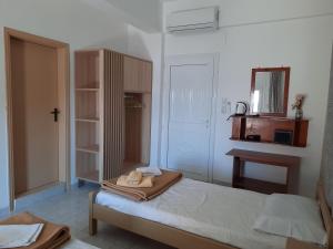 een kleine slaapkamer met een bed en een spiegel bij Voula Beach in Léntas +22 foto's