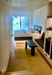ein Schlafzimmer mit einem Bett und einem Tisch darin in der Unterkunft KLIDON Dreamy Living Suites in Mykonos Stadt