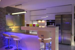 a kitchen with a white counter and stools in it at NICE LIFE - Luxury apartment in the Old Town. in Bratislava