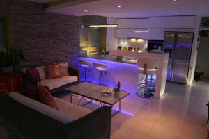 a living room with a kitchen with purple lighting at NICE LIFE - Luxury apartment in the Old Town. in Bratislava