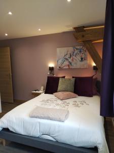 um quarto com uma grande cama branca num quarto em Chambre d'hôtes LES BRIMBELLES em Gérardmer