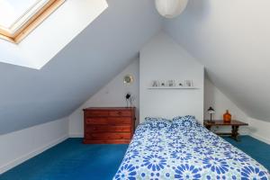 sypialnia z łóżkiem i drewnianą komodą w obiekcie La Grange - Charmante maison à Langrune-sur-mer w mieście Langrune-sur-Mer