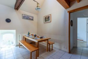 jadalnia z drewnianym stołem i ławką w obiekcie La Grange - Charmante maison à Langrune-sur-mer w mieście Langrune-sur-Mer +6 zdjęć
