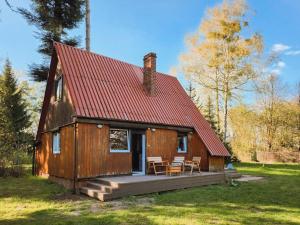 a small cabin with a deck and a red roof at Dom przy Plaży Wieliszew, duży ogród i grill in Wieliszew