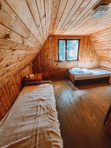 a room with two beds in a wooden cabin at Dom przy Plaży Wieliszew, duży ogród i grill in Wieliszew