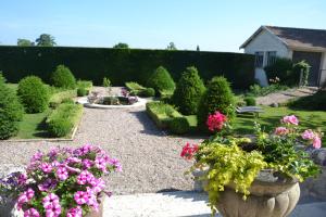 a garden with pink flowers and a fountain at La Villa Champagne Ployez-Jacquemart in Ludes