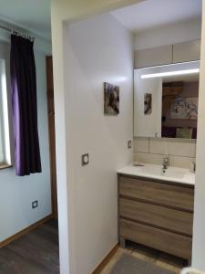 a bathroom with a sink and a mirror at Chambre d'hôtes LES BRIMBELLES in Gérardmer
