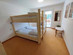 a bedroom with two bunk beds in a room at Zum Hüttenklaus - 12 Personen Gruppenunterkunft in den Bergen mit eigenem Badezuber in Bad Hindelang