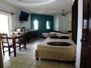 1 dormitorio con 2 camas, mesa y cocina en Gran SAHARA en Playa del Carmen
