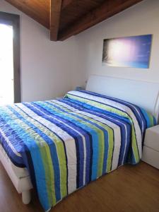 1 dormitorio con 1 cama con manta a rayas en Almare 38, en Grado