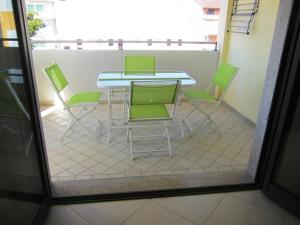un patio con mesa y 4 sillas verdes en Almare 38, en Grado