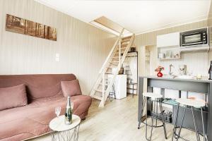 a living room with a couch and a kitchen at POP'S colors - Chalet dans les Vosges in Ventron