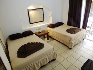 Habitación de hotel con 2 camas y espejo en Gran SAHARA en Playa del Carmen