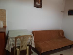 una camera con tavolo, sedia e divano di Voula Beach a Lentas