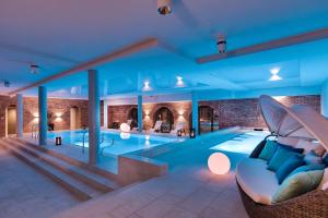 uma grande piscina com um sofá num quarto em Talaria Resort&Spa em Trojanów