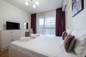 Un dormitorio con una gran cama blanca y una ventana en Labyrinth Apartment - free parking space included, en Varna