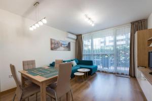- un salon avec un canapé bleu et une table dans l'établissement Labyrinth Apartment - free parking space included, à Varna