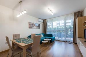 a living room with a blue couch and a table at Labyrinth Apartment - free parking space included in Varna City