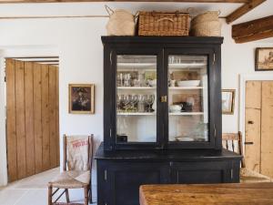 a black cabinet with dishes in it in a room at Little Oakley Cottage in Sandford Saint Martin