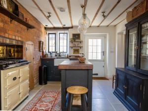 Little Oakley Cottage في Sandford Saint Martin: مطبخ مع دواليب زرقاء وكاونتر مع كرسي +27 صورة