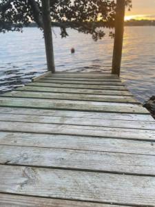 a wooden dock on a lake with the sun setting at * The Dock Condo * Waterfront zen in Bluewater in Niceville