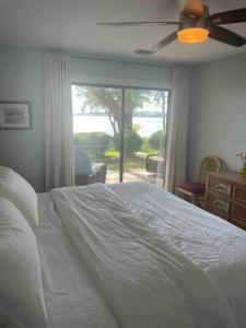 a bedroom with a white bed and a window at * The Dock Condo * Waterfront zen in Bluewater in Niceville
