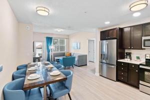 a kitchen and dining room with a table and blue chairs at 4012 Breakview Drive 210 in Orlando