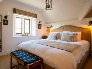 a bedroom with a large bed with a wooden headboard at Little Oakley Cottage in Sandford Saint Martin