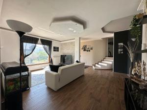 a living room with a white couch and a television at Villa MA-YA in Santa Maria Imbaro