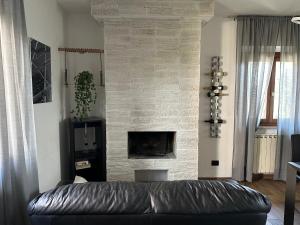 a living room with a leather couch in front of a brick fireplace at Villa MA-YA in Santa Maria Imbaro