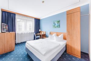 a hotel room with a large bed and a television at Hotel Isartor in Munich +73 photos
