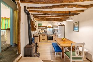 uma cozinha e sala de jantar com uma mesa e um fogão a lenha em La lechuga azul em Güéjar-Sierra