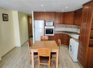 a kitchen with a wooden table with chairs and a sink at Sea view apartment in Cullera