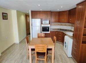 kuchnia z drewnianym stołem z krzesłami i zlewem w obiekcie Sea view apartment w mieście Cullera