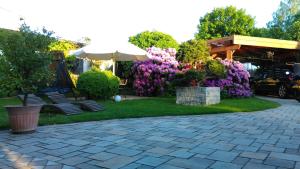 een terras met stoelen, een parasol en bloemen bij Ferienwohnung am Kurpark Ostrau in Bad Schandau