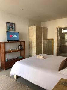 Schlafzimmer mit einem großen weißen Bett und einem Flachbild-TV in der Unterkunft Amalfi Villa in Grand Baie