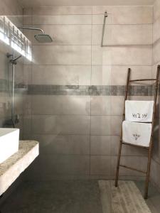 a bathroom with a shower with a chair and a sink at Amalfi Villa in Grand Baie