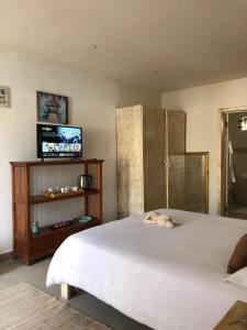 a bedroom with a large white bed and a flat screen tv at Amalfi Villa in Grand Baie