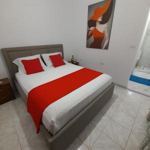 a bedroom with a large bed with red pillows at Luxury Dennis Home in Sarandë