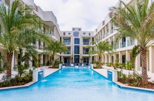 a swimming pool in front of a building with palm trees at Wariruri 209 in Palm-Eagle Beach