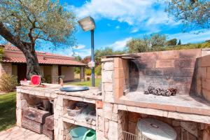 a stone outdoor kitchen with a brick wall at Villa Luna Smeralda ad Alghero villa con piscina ad uso esclusivo per 8 persone in Alghero